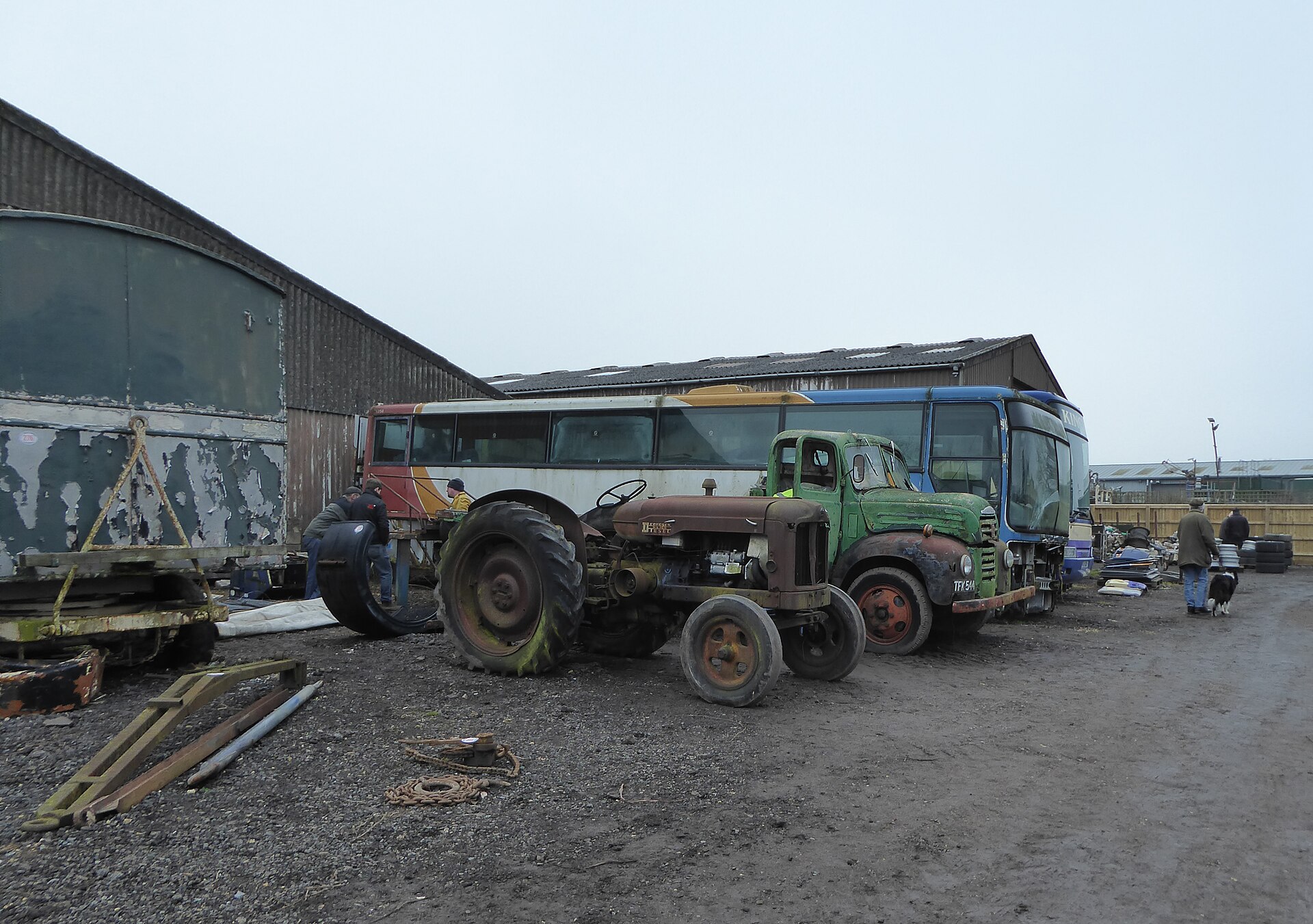Vehicles and machinery lined up across a field ahead of a farm auction
